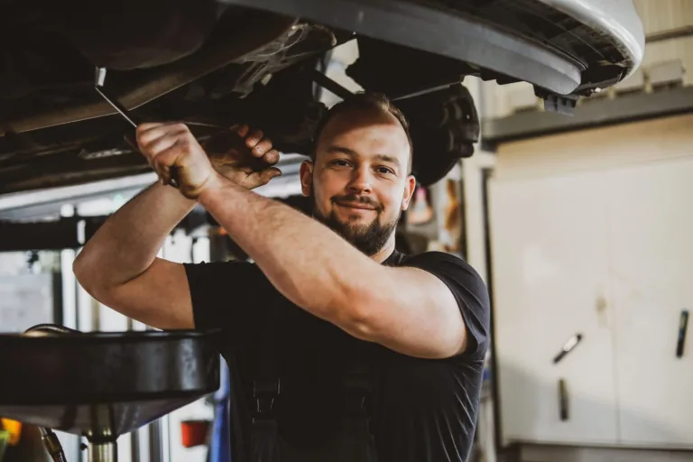 Mechaniker arbeitet über Kopf an einem Fahrzeug auf der Hebebühne